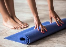 Unrolling yoga mat at pilates class