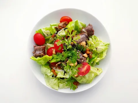 Salad on a white plate with tomatoes and vegetables